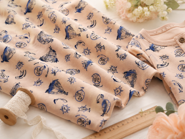 Single jersey knit with a nautical print on a peach background